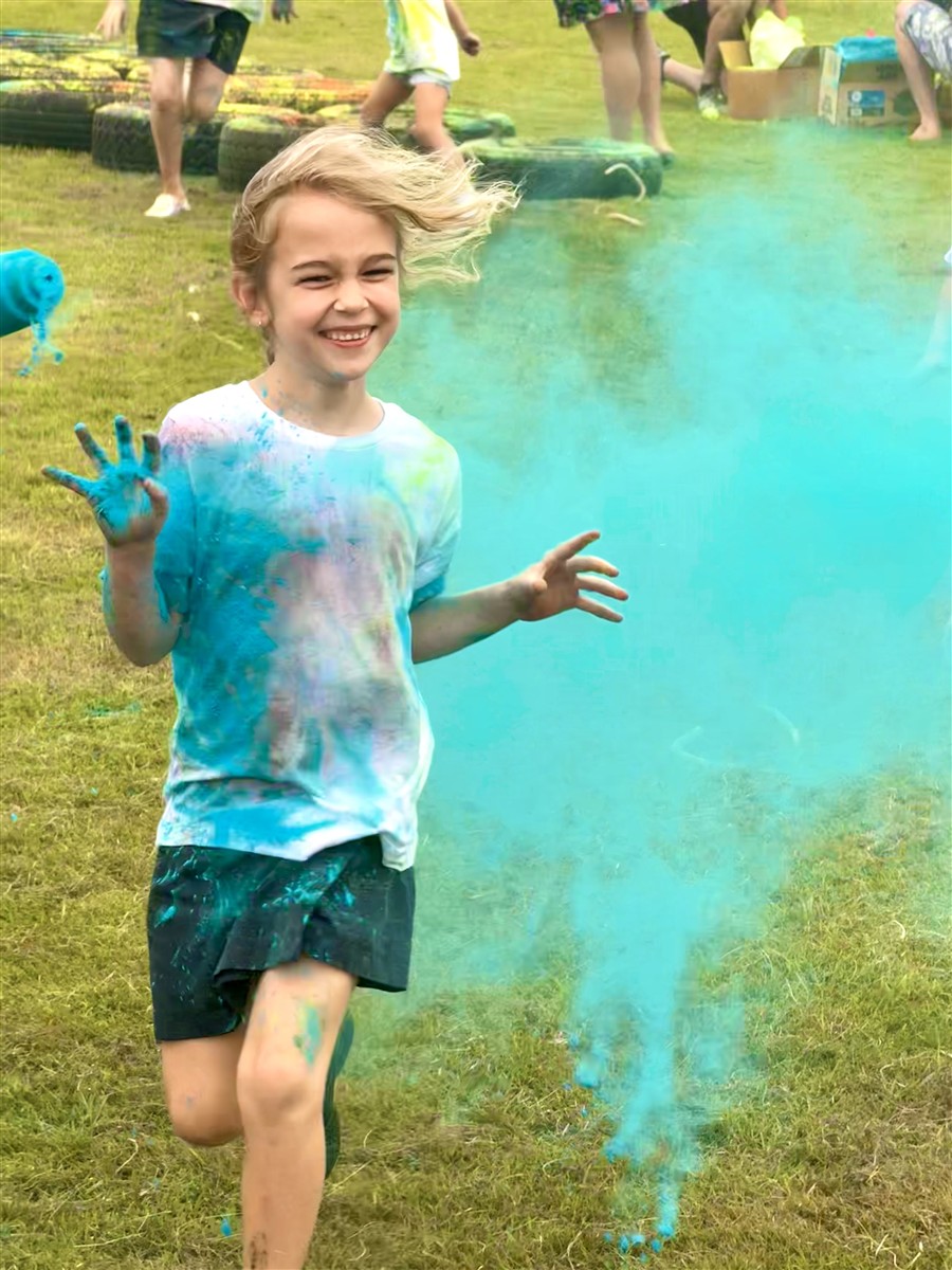 A girl running through a colourful cloud